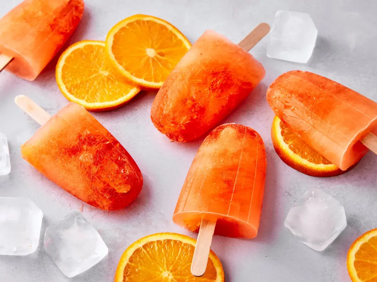Erfrischendes Aperol Spritz Eis mit Orangenscheiben und Eiswürfeln. Perfekt für heiße Sommertage.
