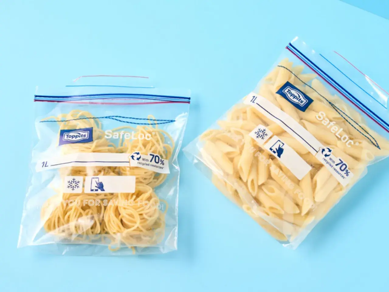 Zwei Zip-Beutel mit Nudeln, bereit zum Einfrieren. Einer enthält Spaghetti, der andere Penne.