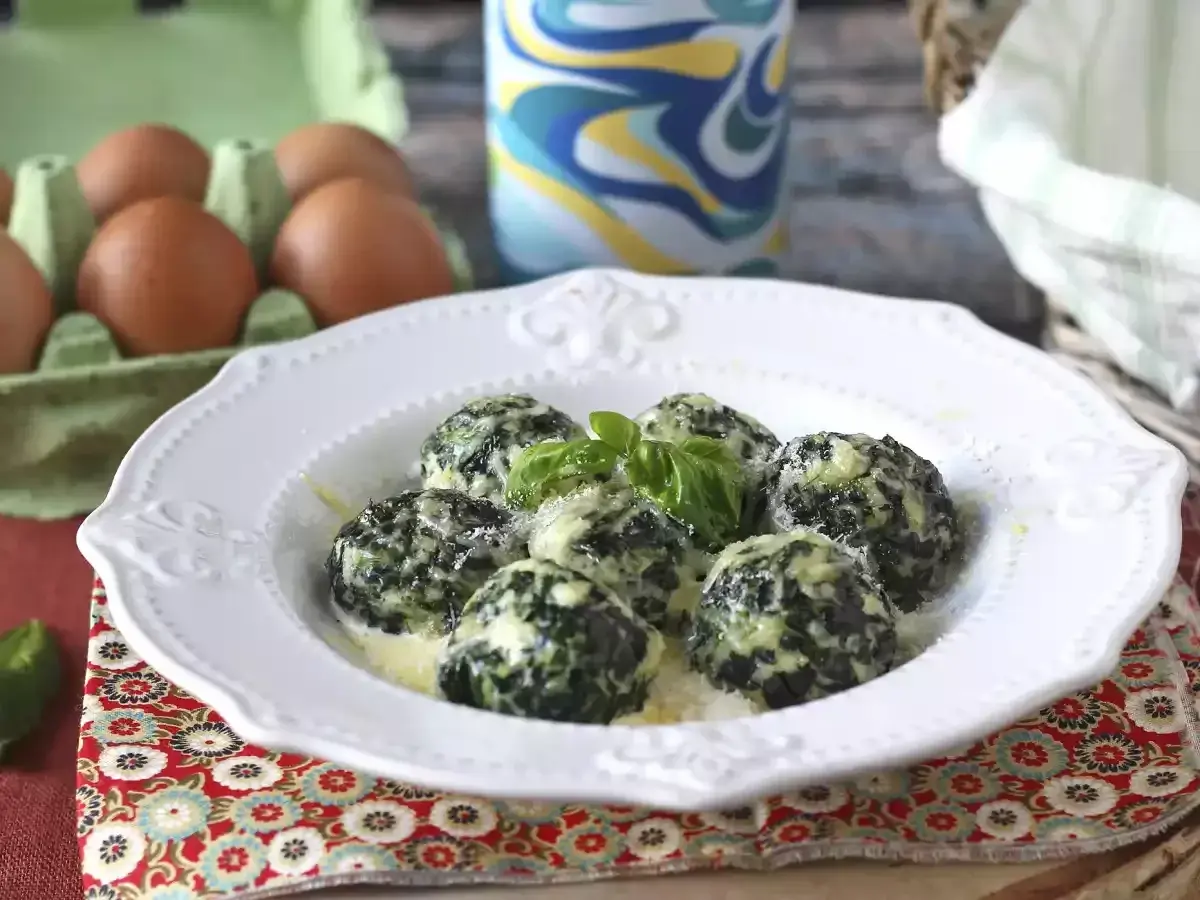 Malfatti rezept: Grüne, käsige Klößchen mit Spinat und Basilikum auf einem Teller, daneben Eier im Karton.