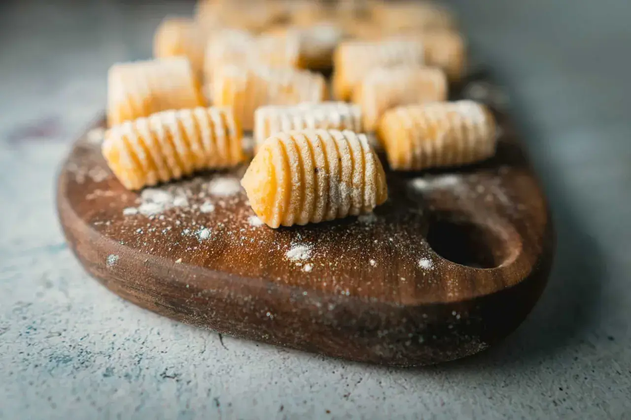 Frisch zubereitete Gnocchi liegen auf einem Holzbrett. Diese kleinen Teigklößchen sind ein Klassiker der italienischen Küche.