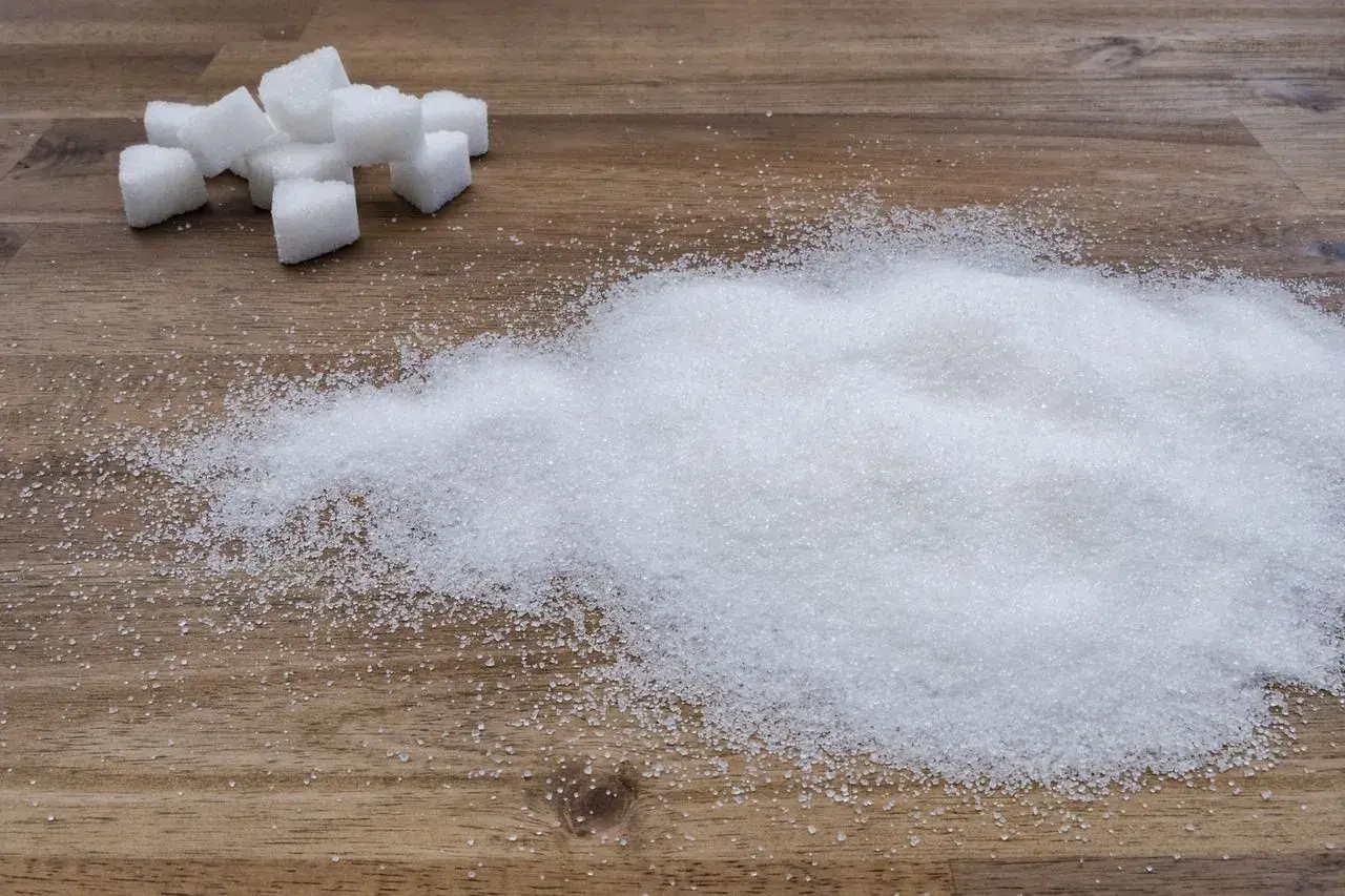 Zuckerwürfel und ein Haufen feiner Kristalle, die an eine süße Versuchung erinnern, fast wie eine Prise Zucker für den Rotwein.