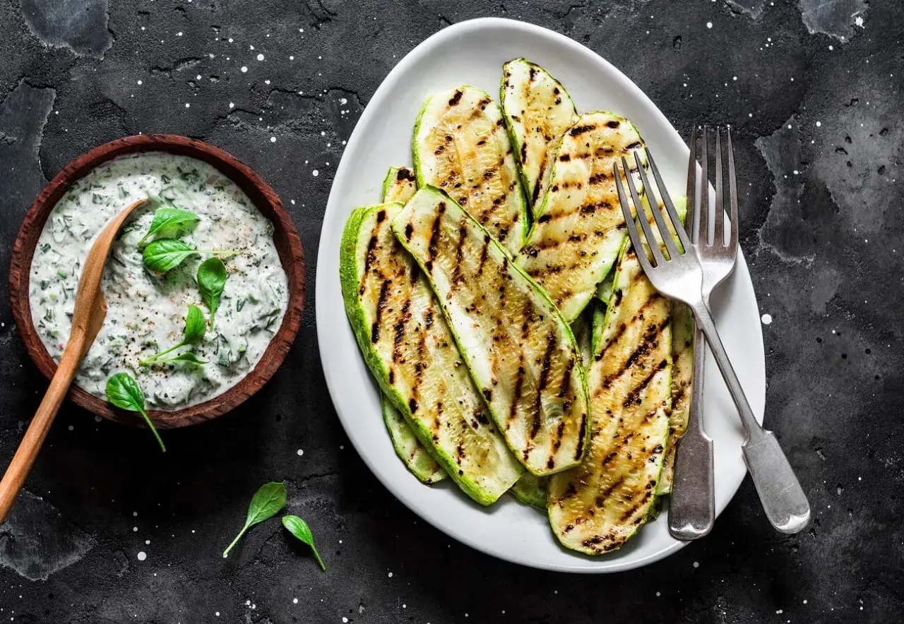 Gegrillte Zucchinischeiben mit Kräuterquark. Perfekt zum **Zucchini zubereiten** für einen leichten Genuss.