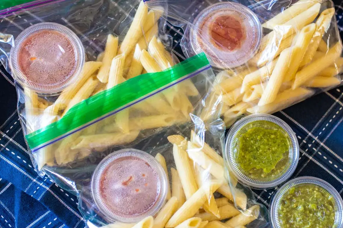 Penne-Nudeln mit Saucen in Plastikbeuteln, bereit zum Einfrieren.
