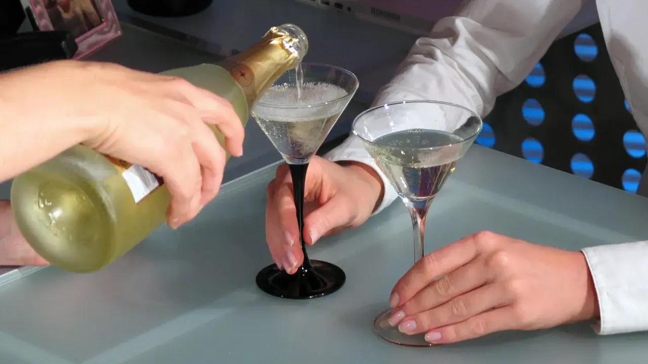 Hände gießen Prosecco in Gläser. Man fragt sich, kann Prosecco schlecht werden, wenn er so frisch serviert wird?