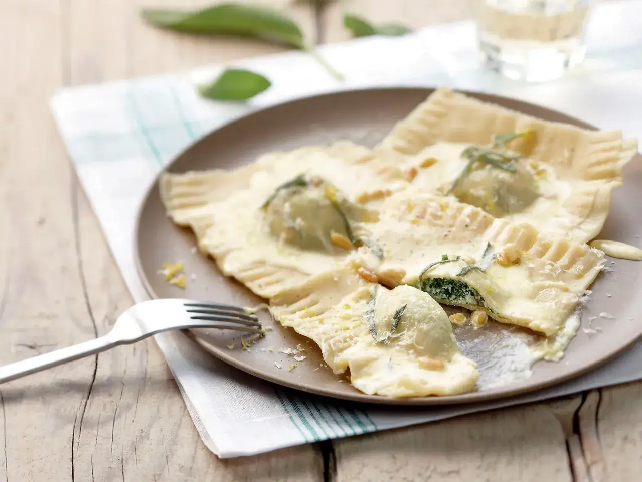 Spinat Ricotta Tortellini in cremiger Salbeibutter mit Pinienkernen und Zitronenschale.