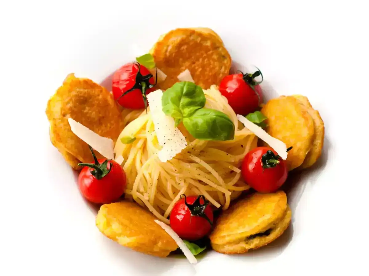 Zucchini Piccata: goldbraune Zucchinipuffer umgeben Spaghetti, Kirschtomaten und Parmesan. Ein köstliches Gericht.