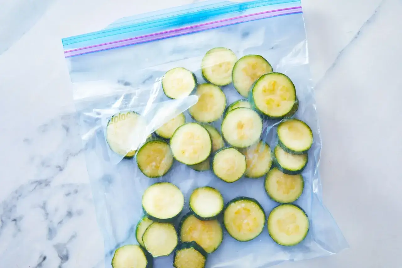 Gefrorene Zucchinischeiben in einem Ziploc-Beutel, bereit zur Lagerung. Perfekt f&uuml;r zuk&uuml;nftige Mahlzeiten.
