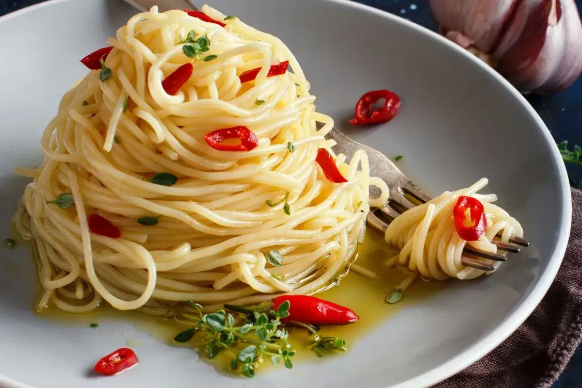 Spaghetti mit Knoblauch, &Ouml;l und Chili (aglio olio e peperoncino), garniert mit frischen Kr&auml;utern und roten Chilischeiben.