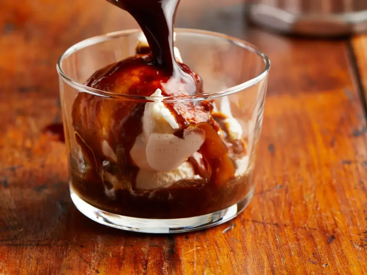 Ein Glas mit cremigem Vanilleeis, übergossen mit dunklem Espresso. Ein Genuss für die Sinne.