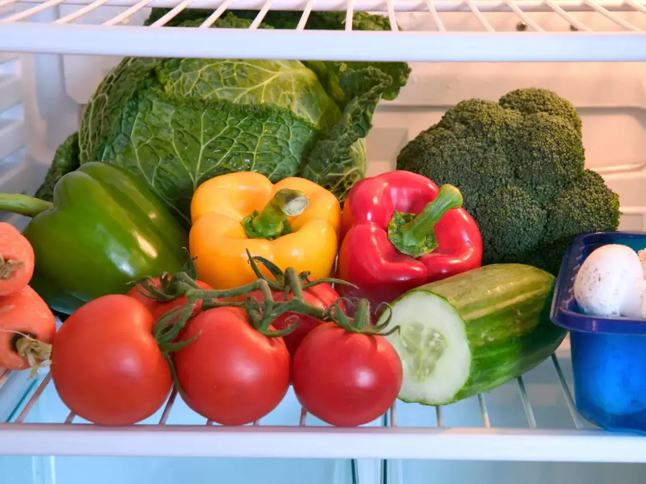 Bunte Paprika, Tomaten, Gurke, Kohl und Brokkoli lagern im K&uuml;hlschrank.