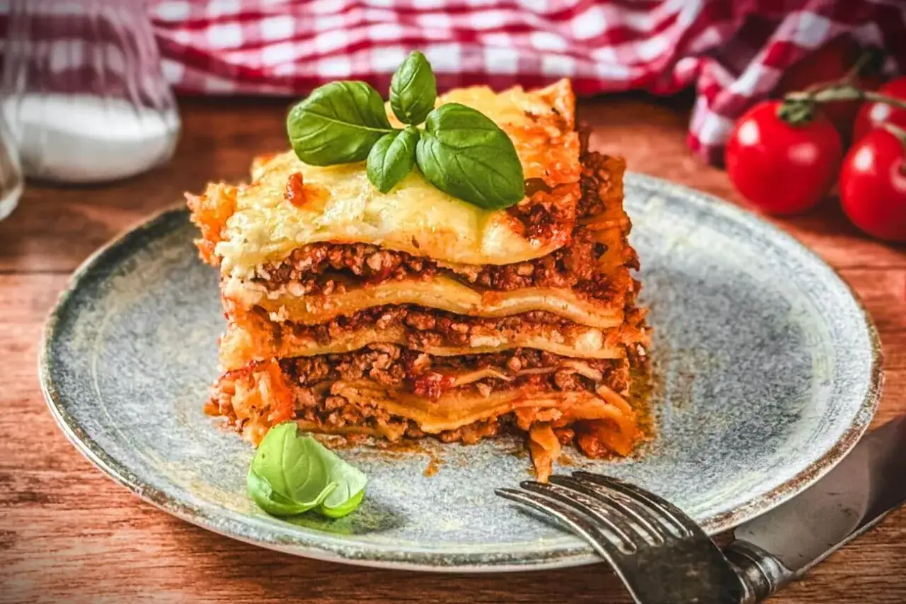Ein saftiges Stück Lasagne mit Hackfleisch, belegt mit frischem Basilikum. Ein köstliches Lasagne Rezept mit Hackfleisch, das zum Genießen einlädt.