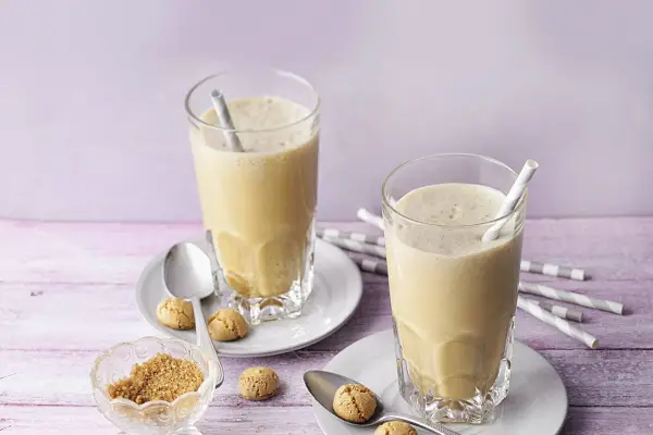 Zwei cremige Espresso Frappés mit Keksen und braunem Zucker.