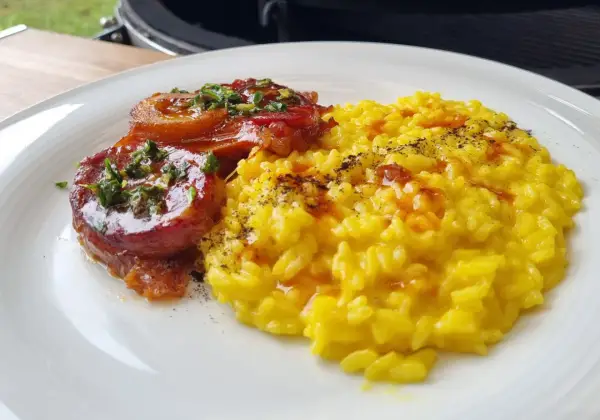 Ossobuco, ein geschmortes Kalbshaxengericht, serviert mit cremigem Safranrisotto.